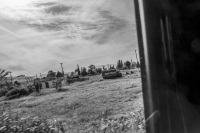 view out of a jeep wranlger in a landscape near euboea with old houses and worker, black-and-white