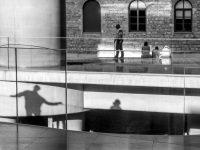 visitors and their shadows at the entrance of the acropolis museum in athens, black-and-white