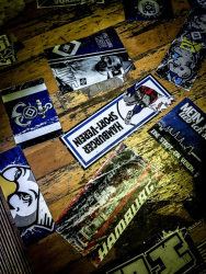 blue-white stickers of the football club hsv are sticking on an old wooden table in the unabsteigbar in hamburg