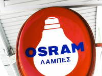 a neon sign for osram lamps is hanging at a store in aegio