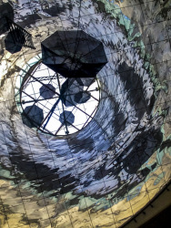 art at a ceiling in athens with purple lights and black umbrellas