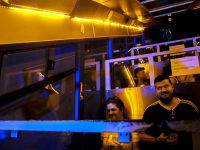 people are sitting in the yellow and blue illuminated lycabettus cable car in athens