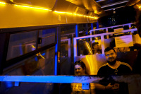 people are sitting in the yellow and blue illuminated lycabettus cable car in athens