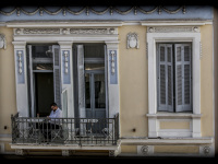 a young man is sitting on balkon of the appartement one three one - in the heart of athens in, which is building in the classicism