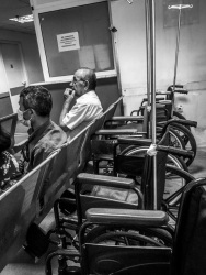 waiting people and some wheelchairs in the hospital of aegio in greece, black-and-white
