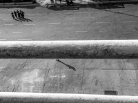 behind a ship railing you see shadows of a pair of feet and of some police officers at the harbor of piraeus, black-and-white