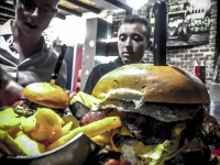 in the restaurant memphis bbq grill in rhodes city two young man are looking behind two fat burger at their food
