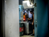 view through a small door on a man who is cutting gyros in archangelos on rhodes