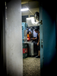 view through a small door on a man who is cutting gyros in archangelos on rhodes