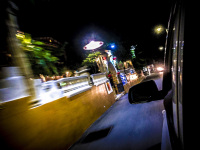 view out of a driving car to the illuminated restaurants in stegna on rhodes