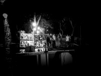 illuminated portraits are standing in an artist park in rhodes city, where tourists are passing at, black-and-white