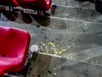 at the end of a football match in the karaiskakis stadion in piraeus you see rests of sunflower seeds next to a red chair