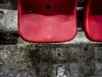 empty sunflower seeds are laying in front of a red chair in the karaikakis stadion in piraeus