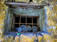 in front of window grills in an old wall in rhodes city are laying four plastic cups
