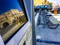 in a computer display in rhodes city reflects the citizens office and at the right are bikes for rent