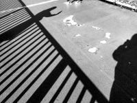 black shadows of a railing and of two people at the hohenzollernbrücke in cologne