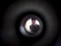 a young man is standing behind a door viewer in the hotel XII apostel in cologne