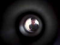 a young man is standing behind a door viewer in the hotel XII apostel in cologne
