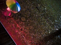 on rained and illuminated cobblestones at the heumarkt in cologne is walking someone with a colorful umbrella