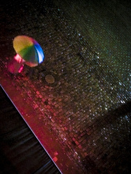 on rained and illuminated cobblestones at the heumarkt in cologne is walking someone with a colorful umbrella