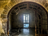 view in the ruine of the mussolini villa in profitis ilias on rhodes, with a window in the background and grafitti at the walls