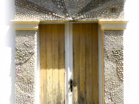a mosaic of shellfishes ist around a yellow door in the old town of rhodes