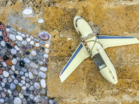 at a yello wall in the old town of rhodes is hanging the housenumber 14, a little plane and a mosaic of stones