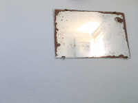 a vintage mirror at a white wall in a restaurants restroom in glyfada on rhodes