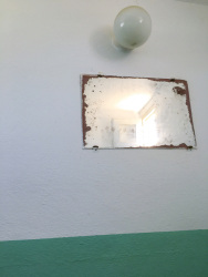a vintage mirror at a white wall in a restaurants restroom in glyfada on rhodes