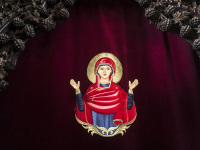 on a red velvet curtain is an embroidered picture of the holy mary in the church of ialysos on rhodes