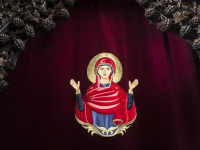 on a red velvet curtain is an embroidered picture of the holy mary in the church of ialysos on rhodes