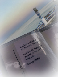 with a sunset sea in the background ist in front am menu card with a text form henry miller, who loves greece