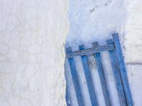 a blue wooden gate stands between white limestone walls in arnitha on rhodes