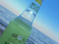 a halffull bottle of mojito classic in front of the sea in stegna on rhodes at sunset