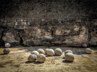 a dozen cannonballs are laying in front of the wall of the grandmaster palace in rhodos old town