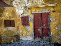 old yello walls with red door and red window in the old town of rhodes