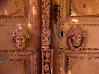 orange rosty door handles with two faces ins relief and a keyhole