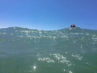 the blue sky at the top and in front the turquoise sea of prasonisi in rhodes, a head is between the scene