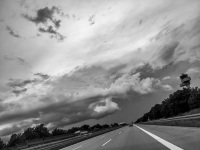 on the road near leipzig in germany with a view on the empty highway with a cloudy sky, black-and-white