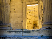 a yellow temple palast on the acropolis in athens with blue-grey steps in front of them