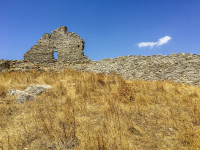 the castle of asklipio on rhodes between yello dry grass an a blue sky with a small clowd