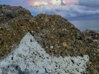 on a brown rock ist painted a big white star and in the background you see a red cloudy sky in diakopto