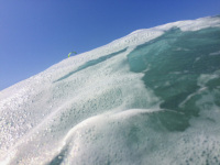behind sea foam you see the blue sky and a green kite in prasonisi on rhodes