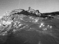 in prasonisi on rhodes a wave is shined by the sun and looks like glass, black-and-white