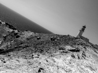 in prasonisi on rhodes is standing an old lighthouse on a rock at the sea, black-and-white