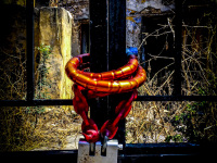 a big red lock closes a black metal door in front of an old yard in the old town of rhodes city