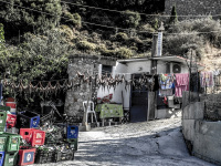in front of an old small house hangs a clothes line full of oktopuses in stegna on rhodes
