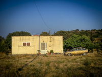 in a evening light landscape stands an old golden citroen next sot a yellow house near theologos on rhodes