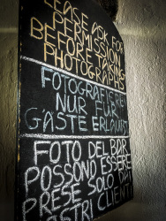 on a blackboard in lindos on rhodes is written in english, german and italian that to photograph is just allowed for customers