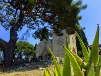 behind a green aloe vera and a pine ist the church of the johannite at filerimos on rhodes
